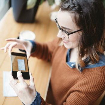 A woman uses Patelco Online to snap a photo of a check and make a mobile deposit with her phone.